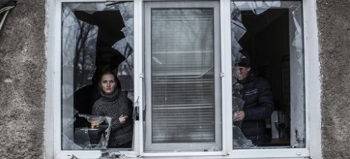 Residents peer out of a home hit by artillery amid renewed violence near the Eastern Ukrainian city of Donetsk. Jaresko’s responsibilities include managing the financial burden of Ukraine’s defense. (Manu Brabo | AP)
