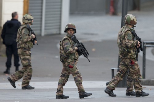French soldiers patrol during a raid in Saint-Denis, near Paris, Wednesday, Nov. 18, 2015. A woman wearing an explosive suicide vest blew herself up Wednesday as heavily armed police tried to storm a suburban Paris apartment where the suspected mastermind of last week's attacks was believed to be holed up, police said. (Photo courtesy of PETER DEJONG |Associated Press)