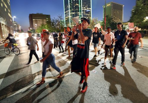Protesters cross Commerce Street during the Next Generation Action Network protest in downtown Dallas, Thursday, Sept. 22, 2016. Dominique Alexander the leader of the Dallas group behind a July march at which five police officers were killed by a sniper has led a downtown Dallas protest rally the day he left prison. He led a rally Thursday night to protest the fatal police shooting of black men in Tulsa, Okla., and Charlotte, N.C. (Tom Fox/The Dallas Morning News via AP)