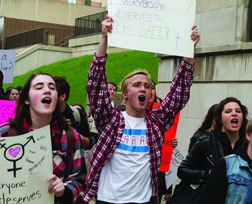 George Elrod (center), a freshman art history major, marches through the Lincoln Park Campus as part of the Take Back The Night rally Thursday, April 24 to "support a lot of my friends," he said. (Grant Myatt/The DePaulia)