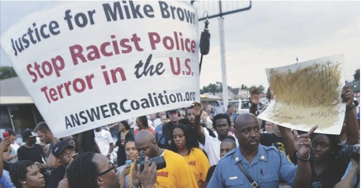 Missouri Highway Patrol Capt. Ron Johnson walks among people protesting the police shooting death of Michael Brown in Ferguson last month. 