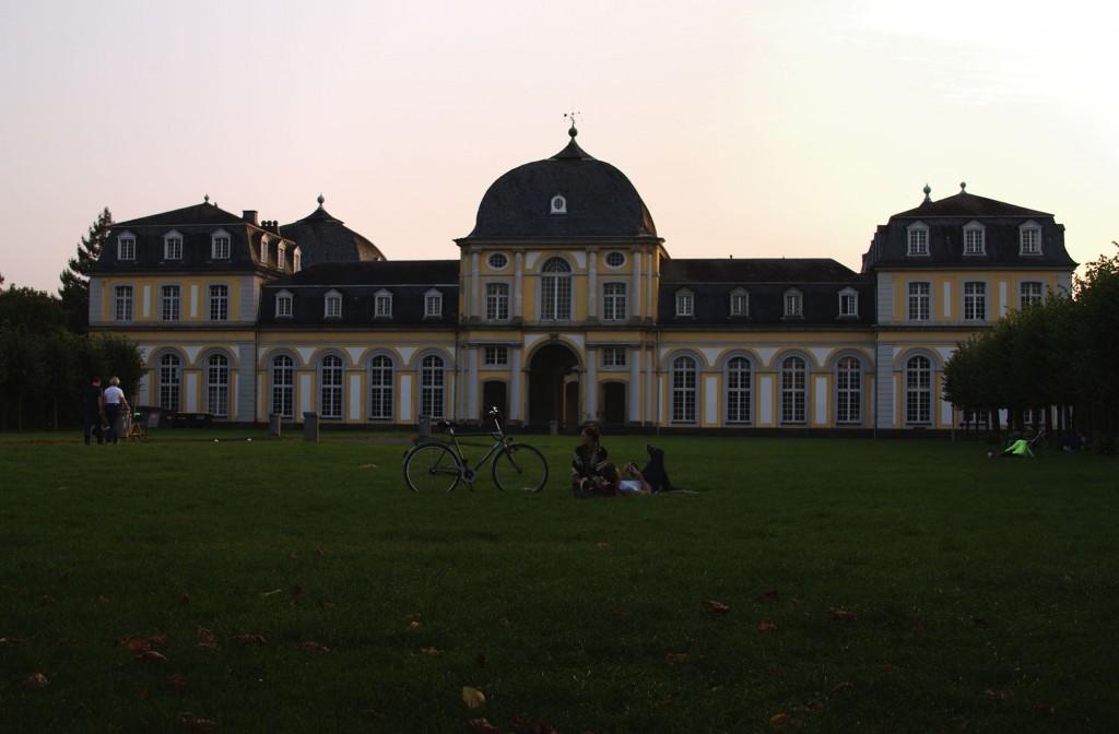 The zoology building of the university clearly matches the Hauptgebäude (main building) and guards the northern edge of the city's botanical gardens. Here students and residents lay out enjoying the cool, summer evening. (Megan Deppen / The DePaulia)