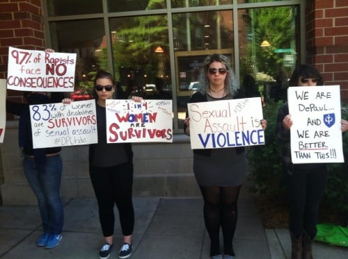 Students hold signs last May protesting DePaul's policies of sexual assault and awareness. (DePaulia File Photo)