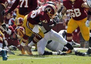 Washington Redskins running back Alfred Morris (46) scores a touchdown as he is hit by Jacksonville Jaguars linebacker Dekoda Watson (57) during the first half of an NFL football game Sunday, Sept. 14, 2014, in Landover, Md. (AP Photo/Evan Vucci)