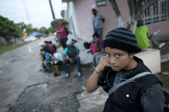 A 14-year-old Guatemalan girl traveling alone waits for a northbound freight train along with other Central American migrants, in Arriaga, Chiapas state, Mexico. More than 52,000 unaccompanied children have been apprehended since October. (AP Exchange)