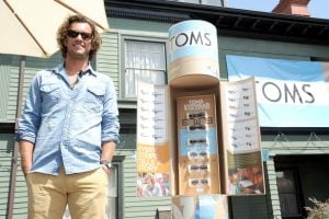 Blake Mycoskie, founder of TOMS, stands near a kiosk of TOMS-branded eyewear. (Photo courtesy of TOMS Shoes)