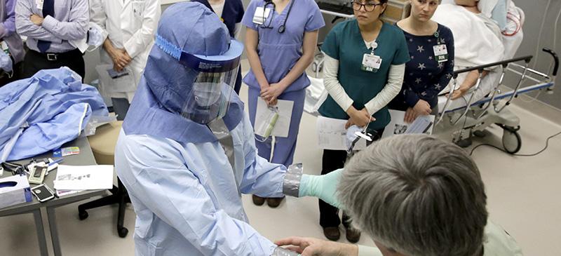 Nurses at Chicago’s Rush University Medical Center demonstrate proper protective procedures during a training class Oct. 16. (Charles Rex Arbogast | AP)