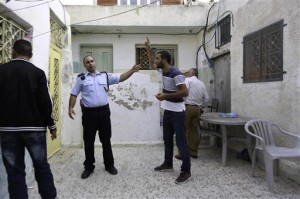 In this photo taken Tuesday, Sept. 30, 2014, Palestinian Mahmoud Qarain, a 30-year-old resident of the east Jerusalem neighborhood of Silwan, argues with Israeli police inside his cousins home, which has been taken over by Jewish settlers. AP Photo/Mahmoud Illean 