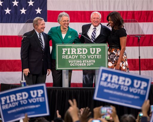 Sen. Dick Durbin, from left, D-Ill., Cook County Board President Toni Preckwinkle, Illinois Gov. Pat Quinn and first lady Michelle Obama pose on stage at a political rally for Quinn on Tuesday, Oct. 7, 2014, at the UIC Pavilion in Chicago. Quinn faces opponent Republican gubernatorial candidate Bruce Rauner in the upcoming election. (AP Photo/Andrew A. Nelles)