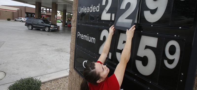 Quick Trip clerk Roxana Valverde adjusts the gas price sign numbers at a QT convenient store in Tolleson, Arizona. Gas prices continue to tumble nationwide. (Ross D. Franklin | AP)