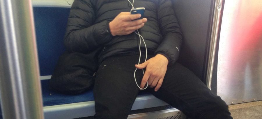 A CTA passenger takes up more than one seat in an act that has come to be called “manspreading.” Some argue the action demonstrates that some men think they can take up more physical space than women. (Courtney Jacquin / The DePaulia)