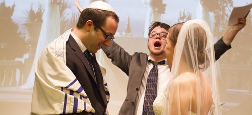 DePaul Jewish Life Coordinator, Matt Charnay, says “Mozel Tov” in the Jewish wedding ceremony between DePaul alumni. (Megan Deppen / The DePaulia)