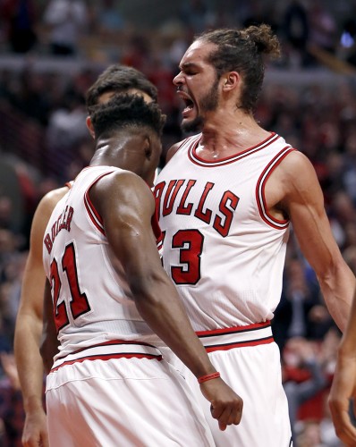 Chicago Bulls center Joakim Noah (13) celebrates with Jimmy Butler (21) after Butler scored during the second half in Game 2 of the NBA basketball playoffs against the Milwaukee Bucks. (AP Photo/Charles Rex Arbogast)