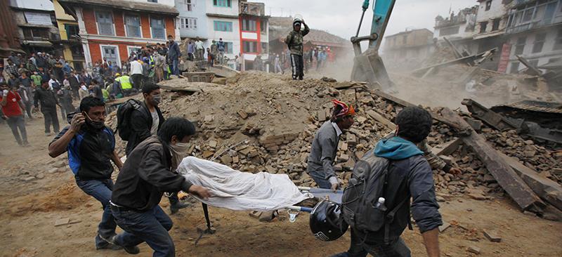 Aid workers rush a victim through the rubble of Kathmandu, Nepal, after a strong earthquake that occurred Saturday, April 25. (AP Photo/ Niranjan Shrestha)