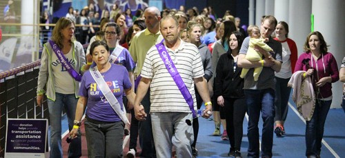 Maria and Mike Ohm (center) lead the way at Relay for Life Friday night. Their daughter Alexa joined Colleges Against Cancer last year to support her mom, who survived breast cancer. Mike said Maria’s chemo therapy was hard to watch, but he is overjoyed to celebrate their 25 wedding anniversary this year. (Megan Deppen / The DePaulia)