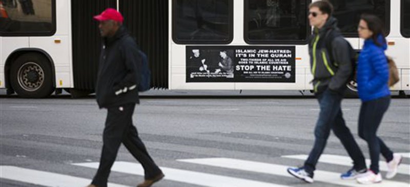 People walk past an anti-Muslim advertisement placed on a Philadelphia public bus. (AP Photo/Matt Rourke)