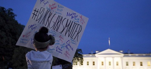 A young girl holds a sign during a protest to support the rallies in Baltimore, in front of the White House, Wednesday, April 29. (AP Photo/Alex Brandon)