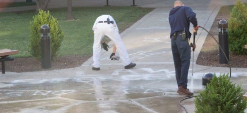 Chalk outlines and writing is washed away on request by Public Safety after the art display put on by Amnesty International at DePaul was shut down late Tuesday night. The chalk that read "law enforcement is not above the law” was washed away early Wednesday morning. 