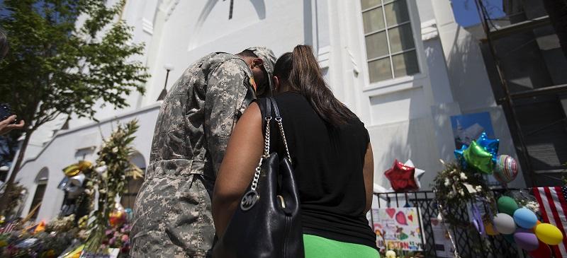U.S. Army Spc. Ron Leary, left and Astride Leary, of Savannah, Ga., pray at a sidewalk memorial in memory of the shooting victims in front of Emanuel AME Church, Monday, June 22, 2015, in Charleston, S.C. (AP Photo/David Goldman)