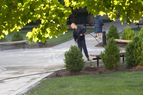 Chalk outlines and writing is washed away on request by Public Safety after the art display put on by Amnesty International at DePaul was shut down late Tuesday night. The chalk that read "law enforcement is not above the law” was washed away early Wednesday morning. 