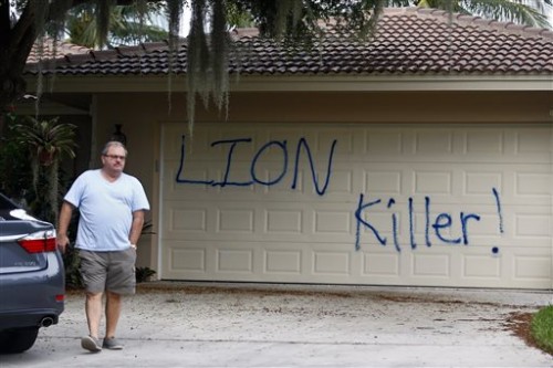 Private Investigator for the Palmer family, Walter Zalisko, of Global Investigative group in Fort Myers walks out of the home Tuesday, Aug. 4, 2015, at the Marco Island home of dentist Walter J. Palmer. Zalisko said no vandalism was found inside. The home was discovered vandalized with the worlds "LION Killer!" and littered with pigs feet drenched in hot sauce. Palmer, a Minnesota resident, is wanted in the killing of Zimbabwe's famous lion, Cecil, a lion who drew thousands of tourists and dollars annually. (Corey Perrine/Naples Daily News via AP)