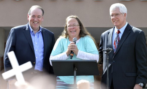 Rowan County Clerk Kim Davis, center with Republican presidential candidate Mike Huckabee, left, and attorney Mat Staver, right, founder of the Liberty Counsel, the Christian law firm representing Davis, at her side, greets the crowd after being released from the Carter County Detention Center, Tuesday, Sept. 8, 2015, in Grayson, Ky. Davis, the Kentucky county clerk who was jailed for refusing to issue marriage licenses to gay couples, was released Tuesday after five days behind bars. (AP Photo/Timothy D. Easley)