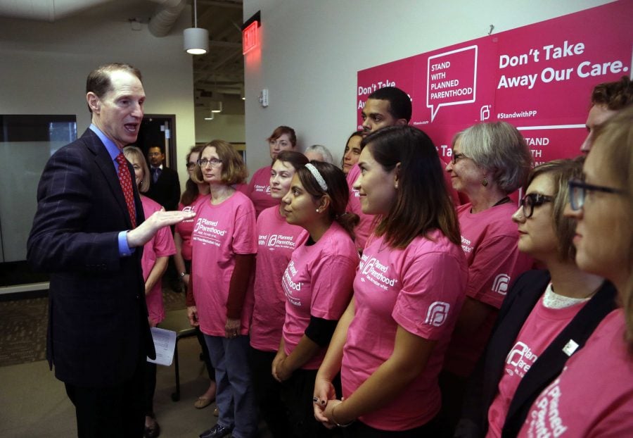 U.S. Sen. Ron Wyden, D-Ore., talks with people at a Planned Parenthood office in Portland, Ore., Friday, Sept. 25, 2015, after speaking about efforts in Congress to de-fund Planned Parenthood. Wyden's support of Planned Parenthood comes amid a heated debate among Oregon politicians over how Planned Parenthood uses the $3.6 million it gets from Oregon.(AP Photo/Don Ryan)