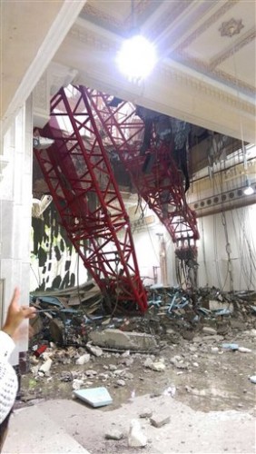 A pilgrim points at a crane that collapsed and killed dozens inside the Grand Mosque in Mecca, Saudi Arabia, Friday, Sept. 11, 2015. The accident happened as pilgrims from around the world converged on the city, Islam's holiest site, for the annual Hajj pilgrimage, which takes place this month. (AP Photo)