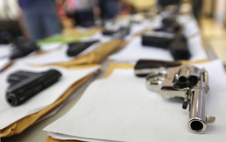 FILE - In this Monday, July 7, 2014, file photo, Chicago police display some of the thousands of illegal firearms they have confiscated so far this year in their battle against gun violence in Chicago. The recent mass shooting at an Oregon community college has put the debate over gun violence and gun control into the center of the presidential race. At least some of the Republicans who are running have pointed to Chicago as proof that gun control laws don't work. (AP Photo/M. Spencer Green)