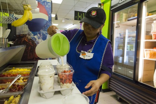 Irma Flores prepares yogur con fruta, made up of extra thick yogurt, strawberries, bananas, mangoes and grapes at La Michoacana. (Photo by Geoff Stellfox | The DePaulia.) 