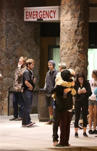 Students embrace outside a hospital emergency room in Flagstaff, Ariz., on Friday, Oct. 9, 2015, after an early morning fight between two groups of college students escalated into gunfire, leaving one person dead and three others wounded, authorities said. The shooting occurred outside a dormitory near the Northern Arizona University campus. (Jake Bacon/Arizona Daily Sun via AP)