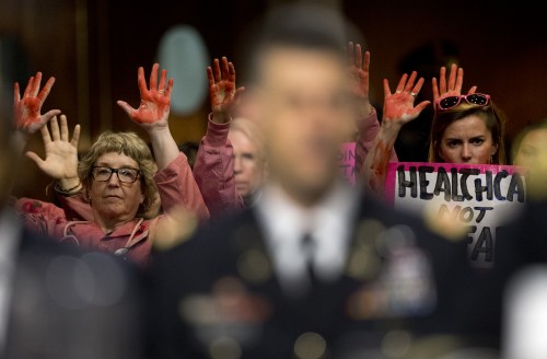 Code Pink members protest the U.S. airstrike on a hospital in Kunduz, Afghanistan behind Gen. John Campbell during the Senate Armed Services Committee hearing Oct. 6, 2015. (Photo courtesy of Carolyn Kaster | AP Photo)