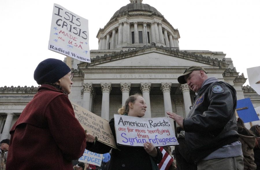 Protesters on opposing sides of the Syrian refugee resettlement issue rally in front of the state Capitol in Olympia, Wash., Friday, Nov. 20, 2015. Washington Gov. Jay Inslee has said the state will welcome refugees and has criticized other governors who have threatened to stop accepting them following last week's terror attacks in Paris. (AP Photo/Rachel La Corte)