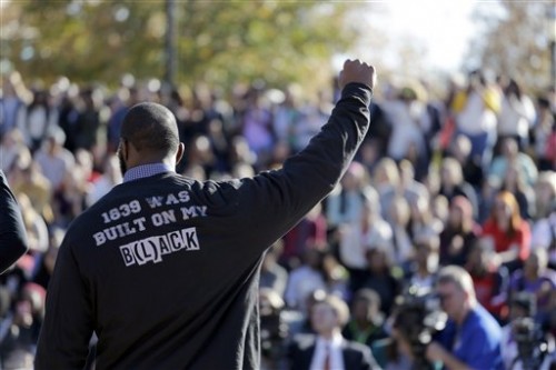 FILE - In this Nov. 9, 2015 file photo, a member of the black student protest group Concerned Student 1950 gestures while addressing a crowd following the announcement that University of Missouri System President Tim Wolfe would resign, at the university in Columbia, Mo. Few paid attention when a black student started a hunger strike at the University of Missouri to protest racial strife on campus. As soon as the football team supported that hunger strike by refusing to practice for or play in the schools lucrative NCAA games, the universitys president and chancellor were forced out and changes were discussed. (AP Photo/Jeff Roberson, File)