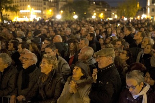 People gather outside for a national service for the victims of the terror attack at Notre Dame cathedral in Paris, Sunday, Nov. 15, 2015. Thousands of French troops deployed around Paris on Sunday and tourist sites stood shuttered in one of the most visited cities on Earth while investigators questioned the relatives of a suspected suicide bomber involved in the country's deadliest violence since World War II. (AP Photo/Daniel Ochoa de Olza)