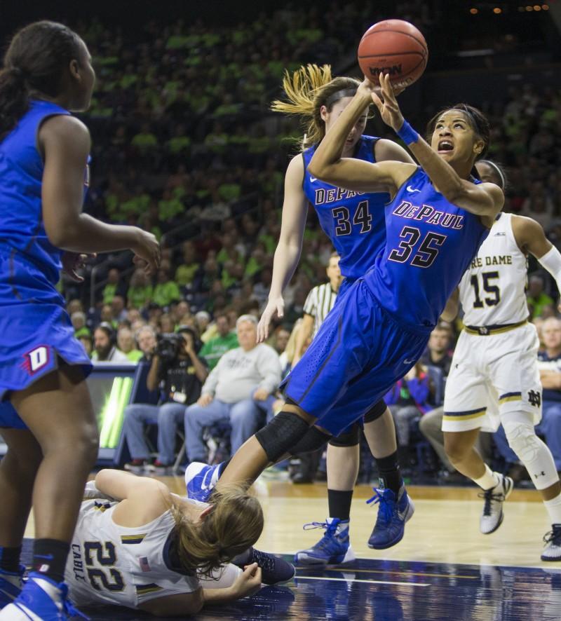 DePauls Mart'e Grays (35) takes a shot as she trips over Notre Dames Madison Cable (22) during the second half of an NCAA college basketball game on Wednesday, Dec. 9, 2015, in South Bend, Ind.  (AP Photo/Robert Franklin)