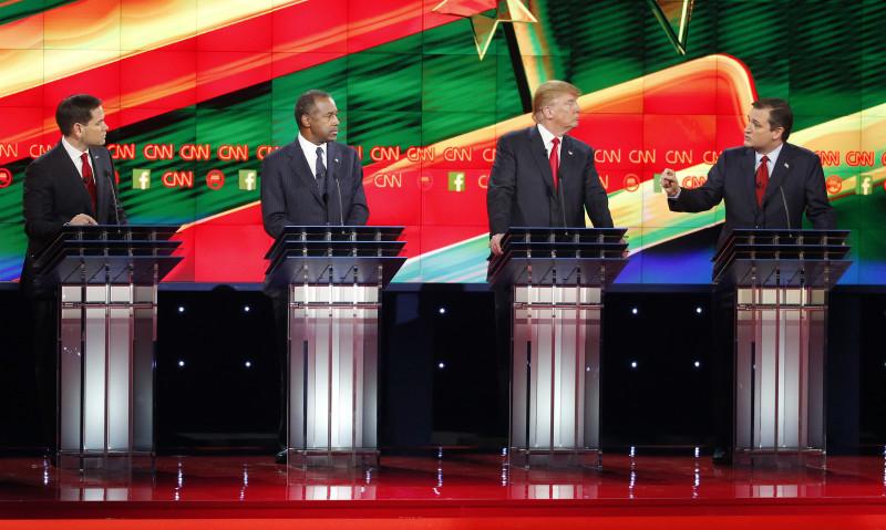 Ted Cruz, right, speaks during an exchange with Marco Rubio, left, as Ben Carson, second from left, and Donald Trump look on during the CNN Republican presidential debate at the Venetian Hotel & Casino on Tuesday, Dec. 15, 2015, in Las Vegas. (AP Photo/John Locher)