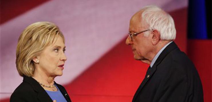 Democratic presidential candidate, Hillary Clinton and Democratic presidential candidate, Sen. Bernie Sanders, I-Vt. speak during a break at the NBC, YouTube Democratic presidential debate at the Gaillard Center, Sunday, Jan. 17, 2016, in Charleston, S.C. (AP Photo/Mic Smith)