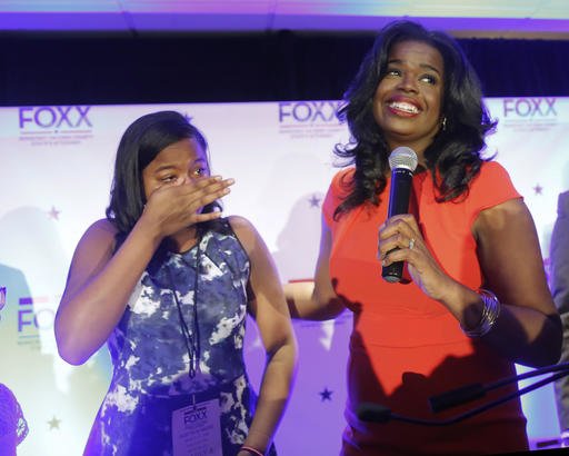 Challenger Kim Foxx , right, smiles at the crowd as her daughter Kai, wipes tears from eyes, as they celebrate Foxx's primary win over incumbent Democratic Cook County State's Attorney Anita Alvarez Tuesday, March 15, 2016, in Chicago. (AP Photo/Charles Rex Arbogast)