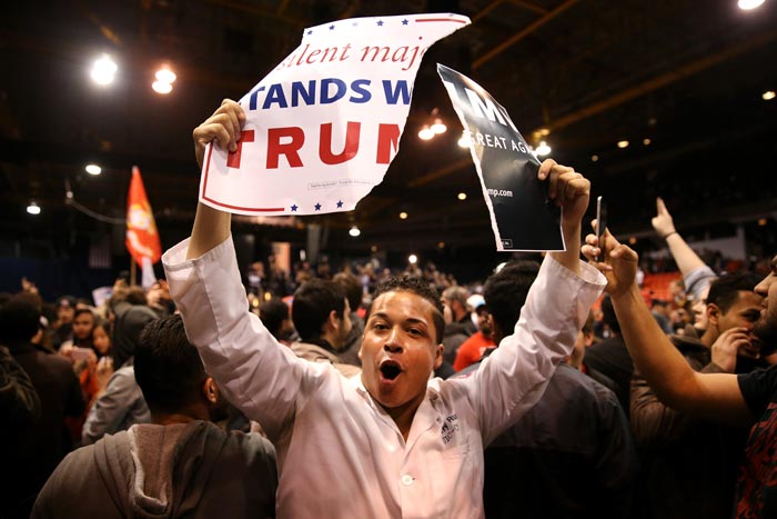 A protester shows off ripped Donald Trump campaign signs after it was announced the rally for the Republican presidential candidate was cancelled at the UIC Pavilion in Chicago on Friday, March 11, 2016. (Chris Sweda/Tribune News Service)