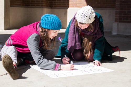 Sophomore political science student Madeline Mosso (right) and sophomore elementary education student Helen Kinskey draw a sign before heading downtown to protest in solidarity with the Chicago Teacher's Union. (Kirsten Onsgard / The DePaulia)