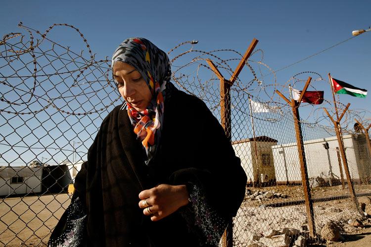 Syrian refugee Samah Qteish, mother of two and pregnant, stands at the perimeter of Zaatari refugee camp in Jordan. Female refugees and others living in the Middle East and other regions face even harrowing conditions, including female genital mutilation. (Carolyn Cole / MCT Campus)