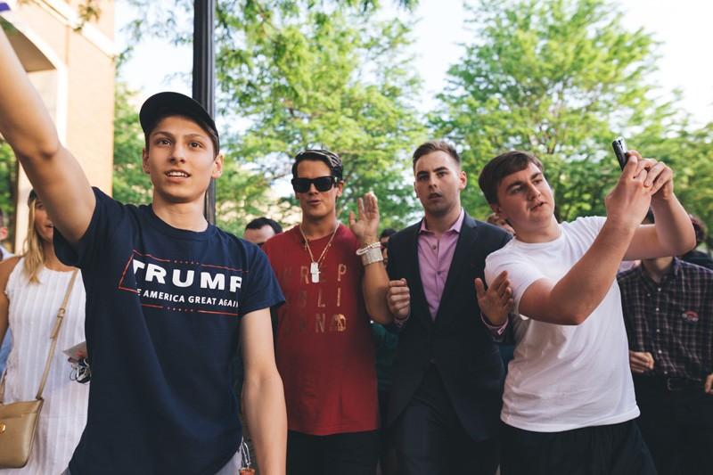 Milo Yiannopoulos and DePaul students walk across campus after Yiannopoulos left his event when protestors interrupted Tuesday. (Josh Leff / The DePaulia)