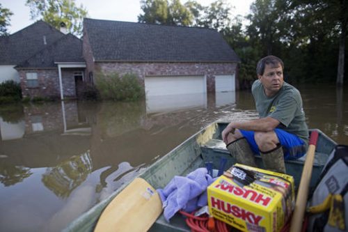 David Key boats away from his flooded home after reviewing the damage in Prairieville, La., Tuesday, Aug. 16, 2016. Key, an insurance adjuster, fled his home as the flood water was rising with his wife and three children and returned today to assess the damage. (Max Becherer | AP Photo)