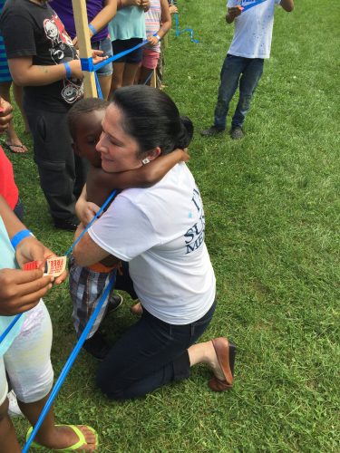 Mendoza hugs a child at the 49th Ward back to school picnic. (Brenden Moore/The DePaulia)