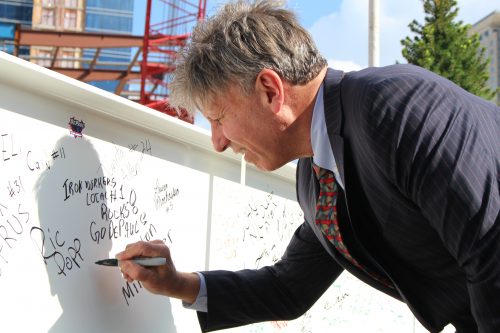 Head women's basketball coach Doug Bruno signs the final beam of the new arena to be placed in a ceremony on Wednesday. (Jack Higgins/The DePaulia)