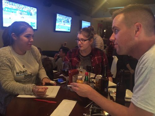 Pictured from left to right: DePaul law students Alex Cox, Katie Wuerstl and Joey Droter mull over a question If/When How's sex trivia night. (Emma Krupp/The DePaulia)