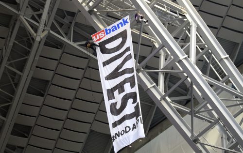 Protesters against the Dakota Access Pipeline rappel from the catwalk in U.S. Bank Stadium during the first half of an NFL football game between the Minnesota Vikings and the Chicago Bears, Sunday, Jan. 1, 2017, in Minneapolis. (AP Photo/Andy Clayton-King)
