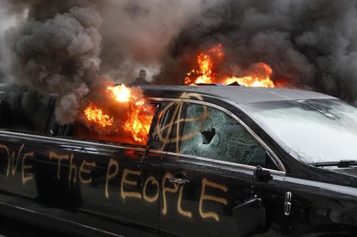 A parked limousine burns during a demonstration after the inauguration of President Donald Trump, Friday, Jan. 20, 2017, in Washington. Protesters registered their rage against the new president Friday in a chaotic confrontation with police who used pepper spray and stun grenades in a melee just blocks from Donald Trumps inaugural parade route. Scores were arrested for trashing property and attacking officers.  (AP Photo/John Minchillo)