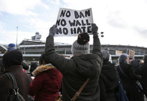 Protesters rally in front of John F. Kennedy International Airport in New York, Sunday, Jan. 29, 2017. President Donald Trump's immigration order sowed more chaos and outrage across the country Sunday, with travelers detained at airports, panicked families searching for relatives and protesters registering opposition to the sweeping measure that was blocked by several federal courts. (AP Photo/Seth Wenig)